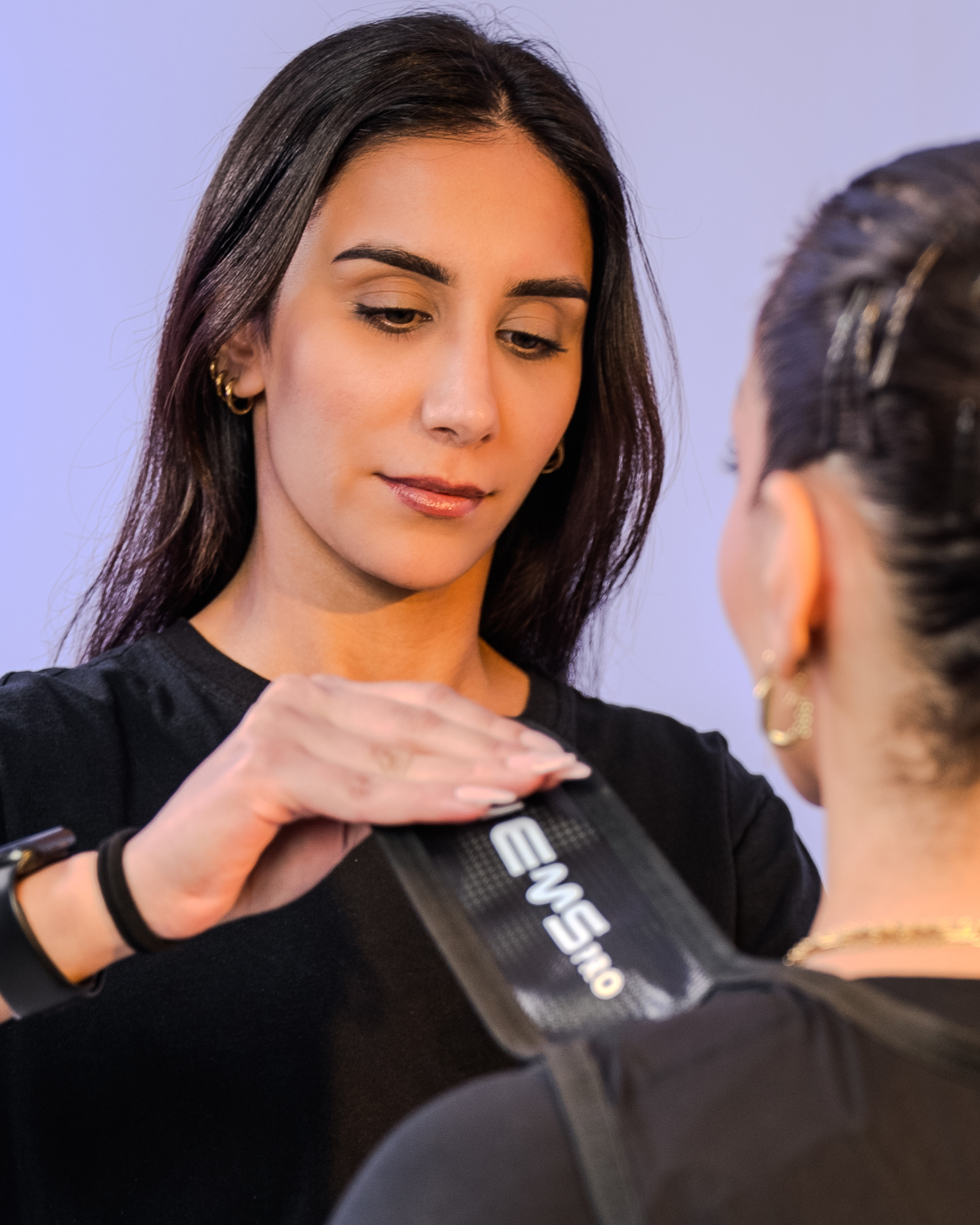 Trainer fitting a Studio 11 client with an EMS suit