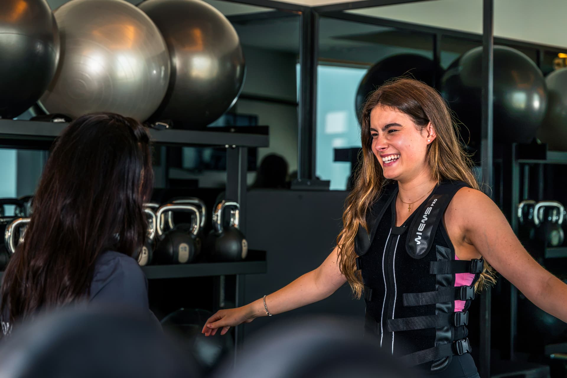 Studio 11 trainer and client smiling during an EMS session